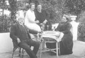 Die ältere und die jüngere Generation der Familie Schön am Tisch im Garten