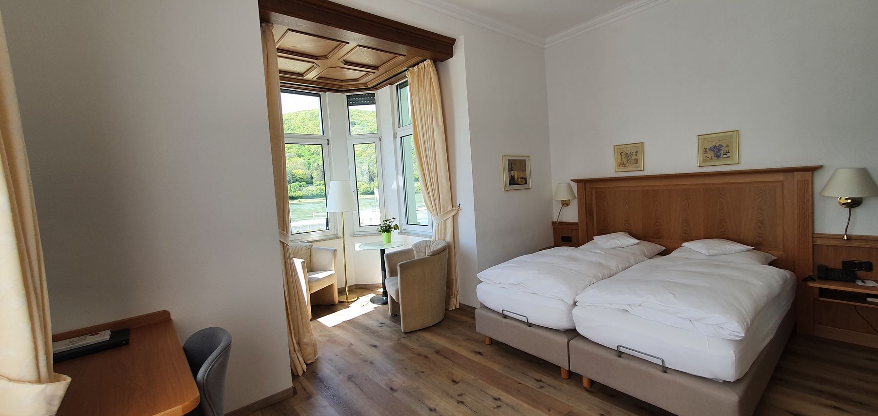 Zimmer mit Erker, Doppelbett und hellem Holzboden